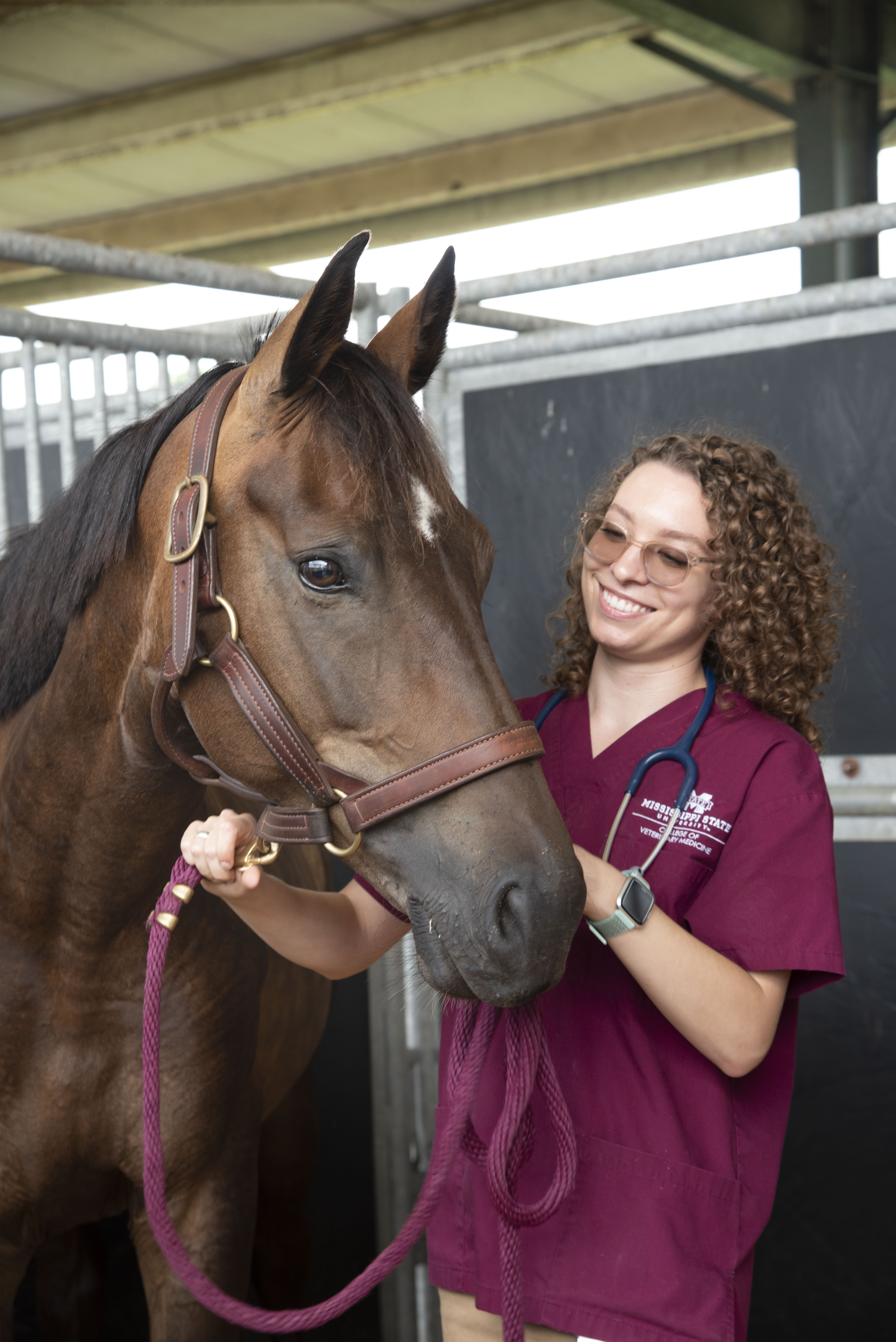 A veterinary student poses with a horse