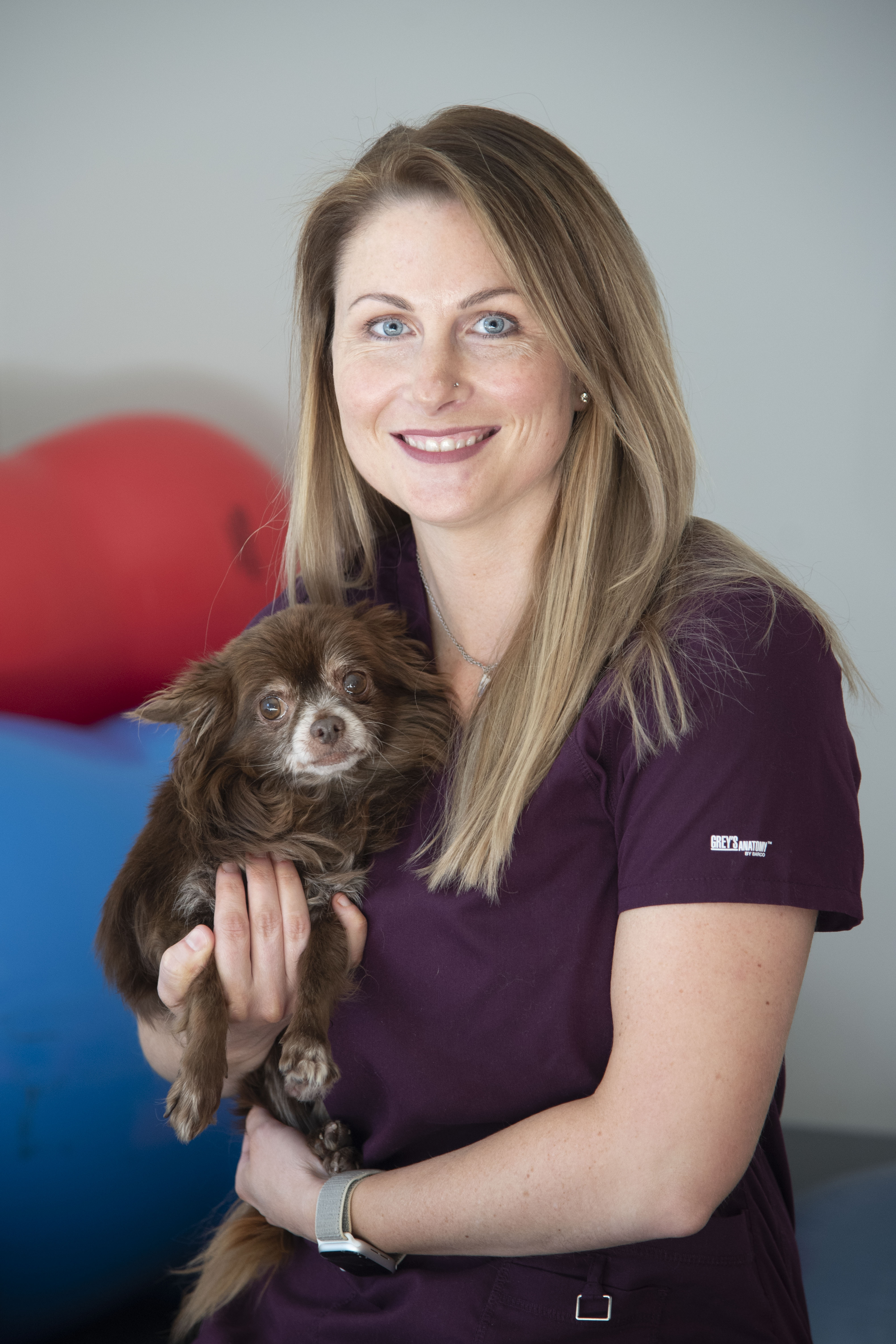 A veterinarian poses with a dog 
